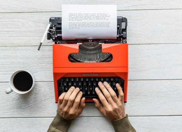 Person writing on typewriter