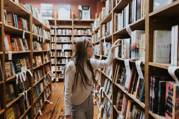 Girl grabbing book off bookshelf